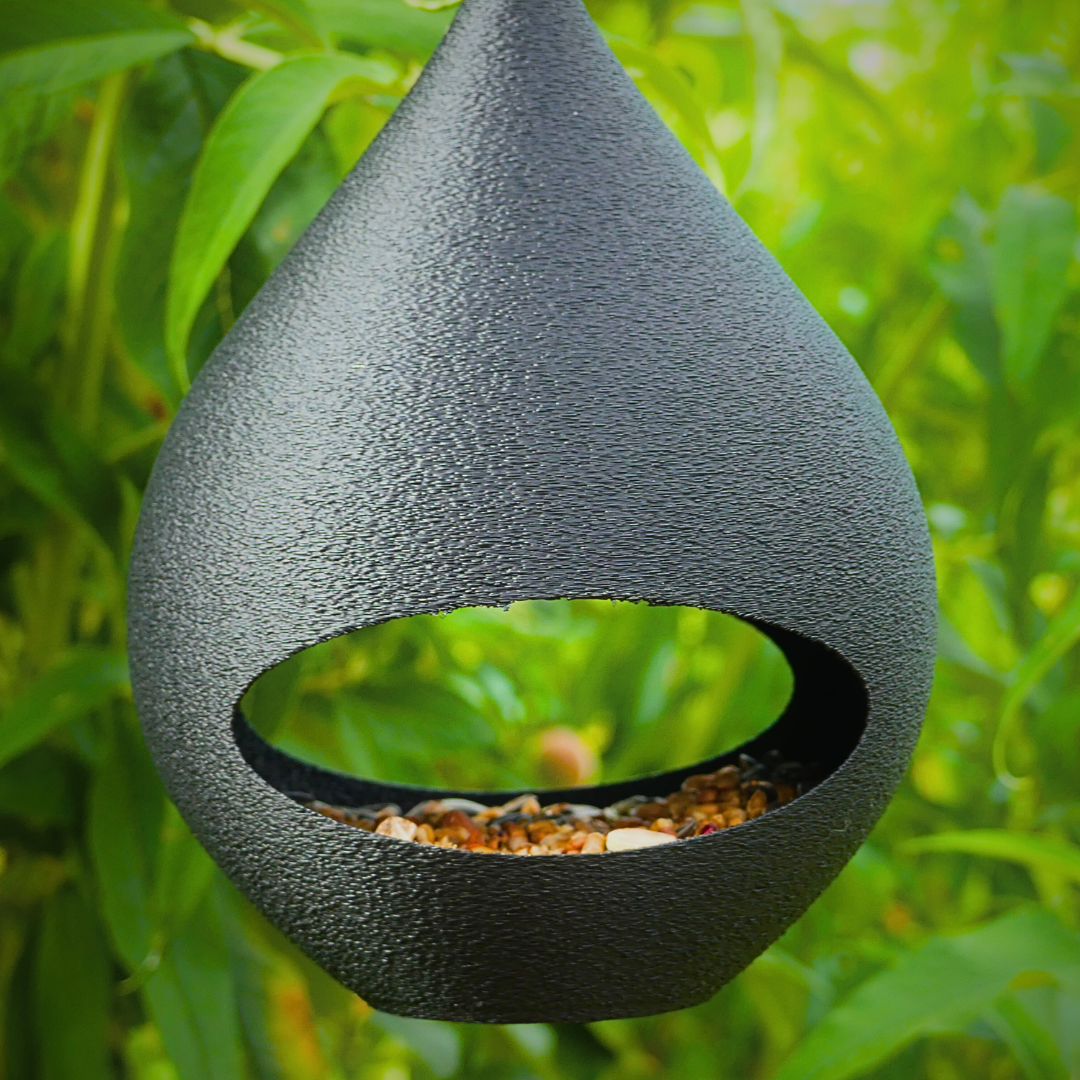 Vogelhäuschen zur Fütterung von Gartenvögeln befüllt mit Körnern
