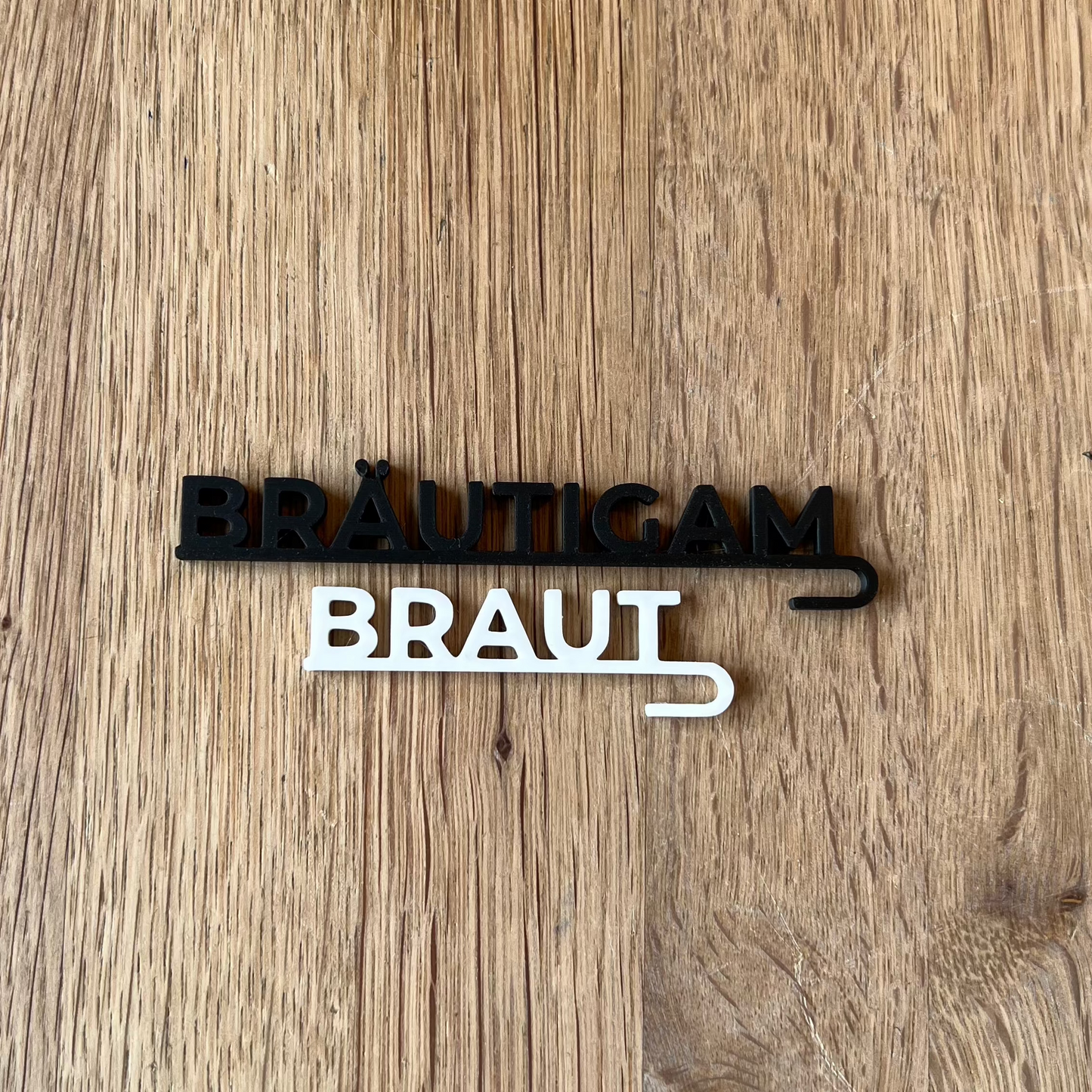 „Nachhaltige 3D-gedruckte Glasanhänger „Braut“ und „Bräutigam“ aus PLA für Hochzeitsgläser dekoriert neben einer Tulpe. Schlichte, elegante Anhänger in Weiß und Schwarz, perfekt für jede Hochzeitsdeko. Diese personalisierten Anhänger verleihen Braut- und Bräutigamsgläsern einen besonderen Touch und passen sich harmonisch verschiedenen Hochzeitsstilen wie Boho, Vintage oder Modern Chic an. Ein umweltfreundliches und elegantes Geschenk zur Hochzeit, das für einen persönlichen Akzent sorgt.“