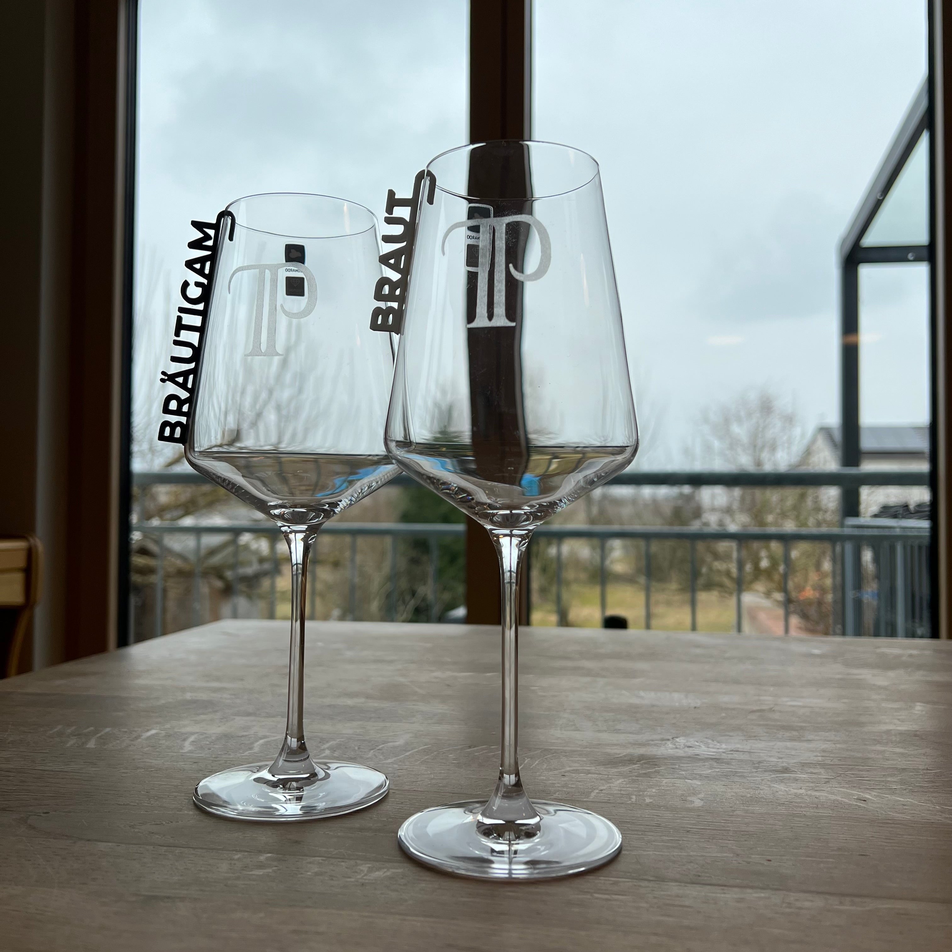 „Nachhaltige 3D-gedruckte Glasanhänger „Braut“ und „Bräutigam“ aus PLA für Hochzeitsgläser dekoriert neben einer Tulpe. Schlichte, elegante Anhänger in Weiß und Schwarz, perfekt für jede Hochzeitsdeko. Diese personalisierten Anhänger verleihen Braut- und Bräutigamsgläsern einen besonderen Touch und passen sich harmonisch verschiedenen Hochzeitsstilen wie Boho, Vintage oder Modern Chic an. Ein umweltfreundliches und elegantes Geschenk zur Hochzeit, das für einen persönlichen Akzent sorgt.“