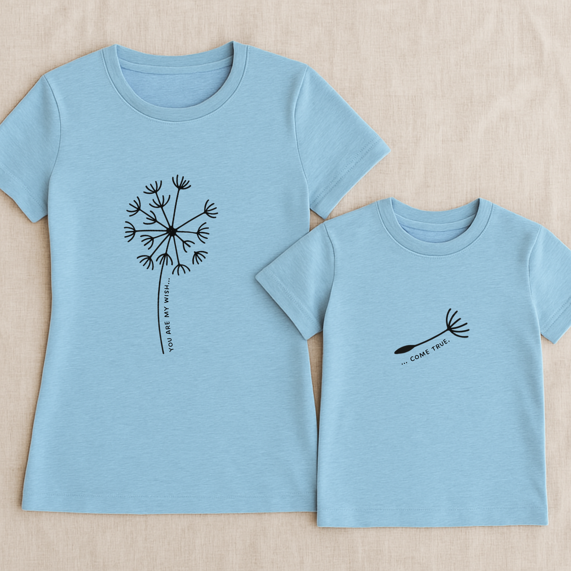 Mama-Kind-Shirt-Set aus Bio-Baumwolle mit geteiltem Spruch: „You are my wish … come true“. Hellblaues T-Shirt für Mama mit Pusteblume und fehlendem Schirmchen, passendes Kind-Shirt mit einzelner Pusteblumenschirmchen-Grafik. Hochwertig, nachhaltig, ideal als Muttertagsgeschenk, zur Geburt oder für Familienfotos. Perfektes Geschenk für Mamas und Kinder – liebevoll, modern und emotional gestaltet.