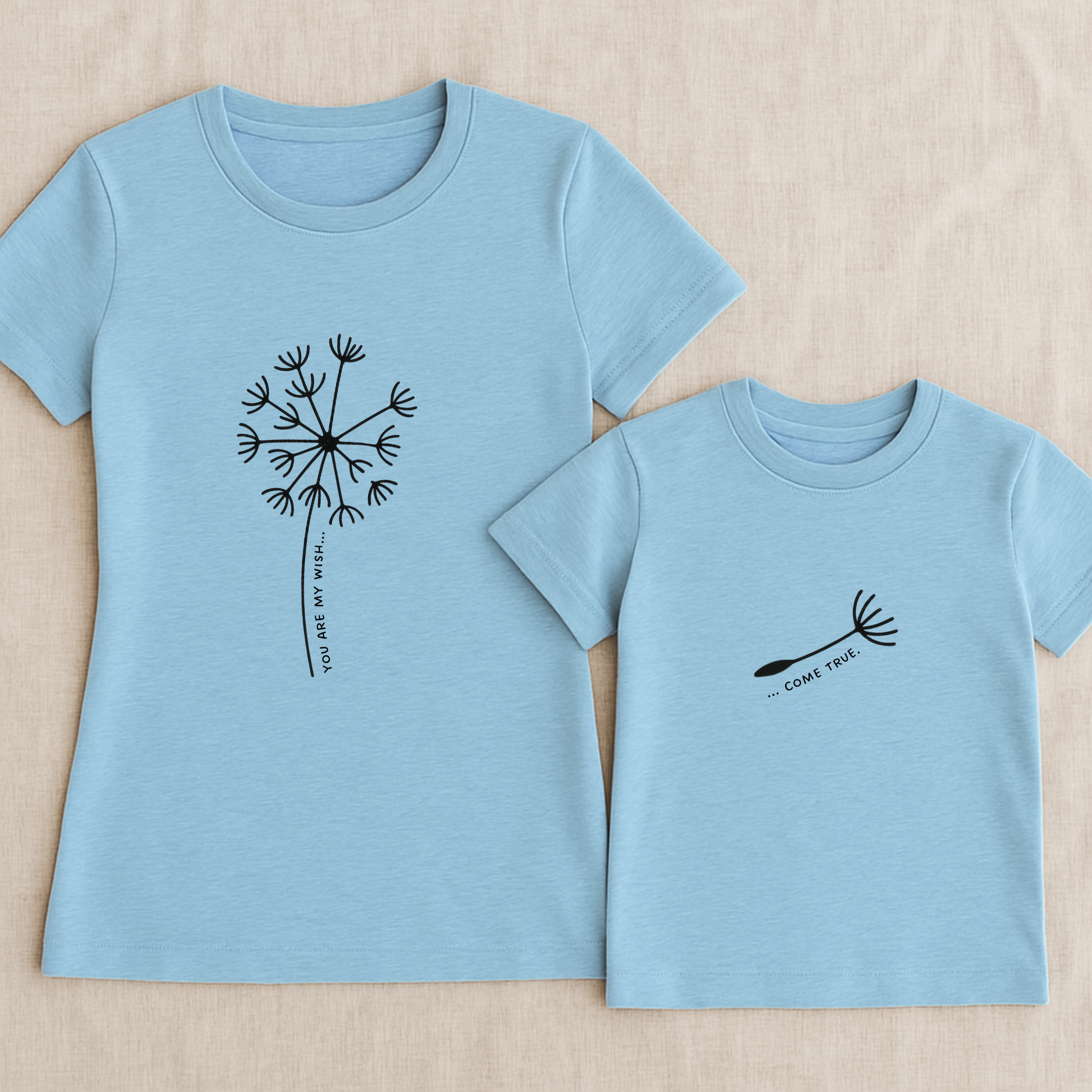 Mama-Kind-Shirt-Set aus Bio-Baumwolle mit geteiltem Spruch: „You are my wish … come true“. Hellblaues T-Shirt für Mama mit Pusteblume und fehlendem Schirmchen, passendes Kind-Shirt mit einzelner Pusteblumenschirmchen-Grafik. Hochwertig, nachhaltig, ideal als Muttertagsgeschenk, zur Geburt oder für Familienfotos. Perfektes Geschenk für Mamas und Kinder – liebevoll, modern und emotional gestaltet.