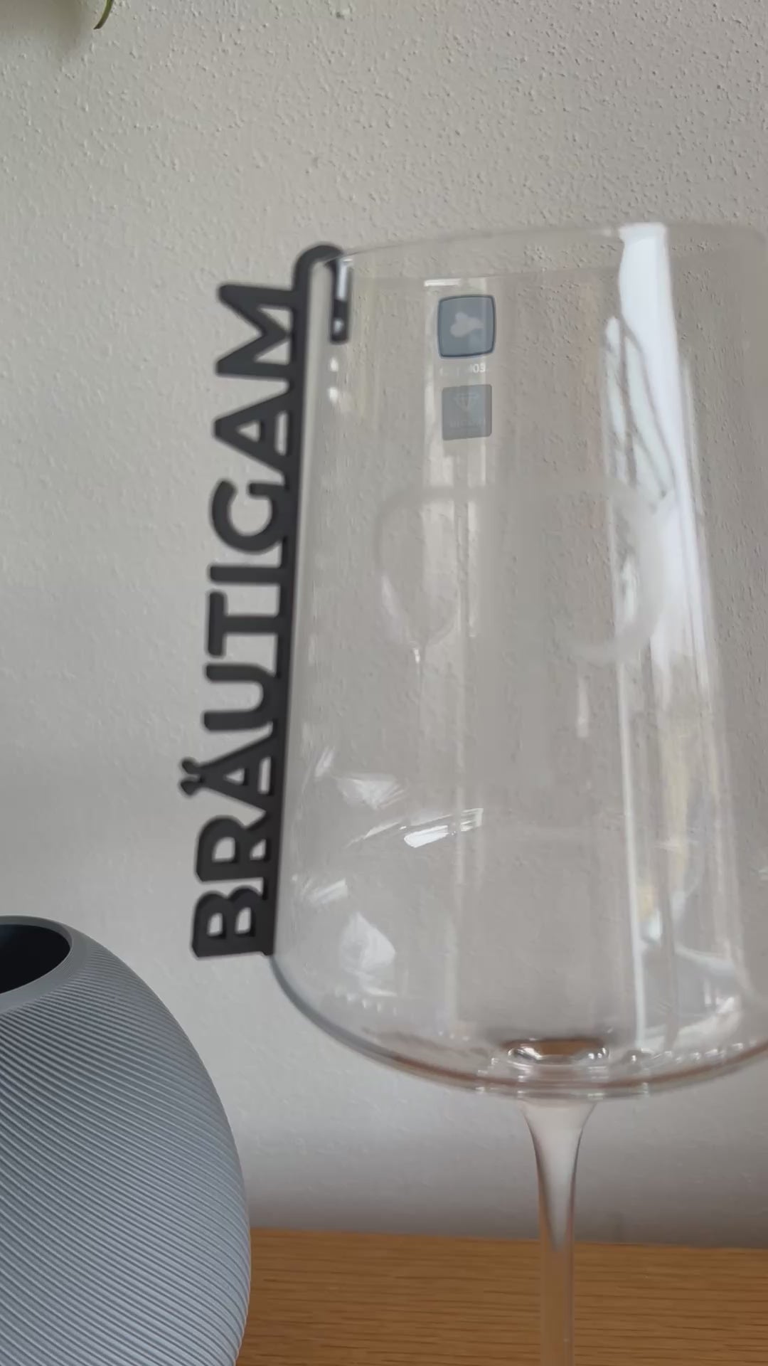 „Nachhaltige 3D-gedruckte Glasanhänger „Braut“ und „Bräutigam“ aus PLA für Hochzeitsgläser dekoriert neben einer Tulpe. Schlichte, elegante Anhänger in Weiß und Schwarz, perfekt für jede Hochzeitsdeko. Diese personalisierten Anhänger verleihen Braut- und Bräutigamsgläsern einen besonderen Touch und passen sich harmonisch verschiedenen Hochzeitsstilen wie Boho, Vintage oder Modern Chic an. Ein umweltfreundliches und elegantes Geschenk zur Hochzeit, das für einen persönlichen Akzent sorgt.“